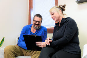 A provider holds a clip-board and explains the benefits of holistic medicine in Coeur d’Alene.