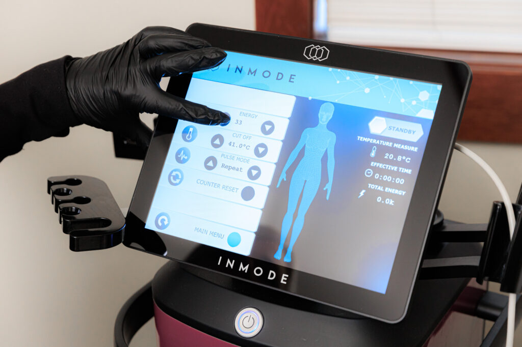 A provider wearing gloves prepares a treatment with FormaV near Hayden using the touchscreen pad.